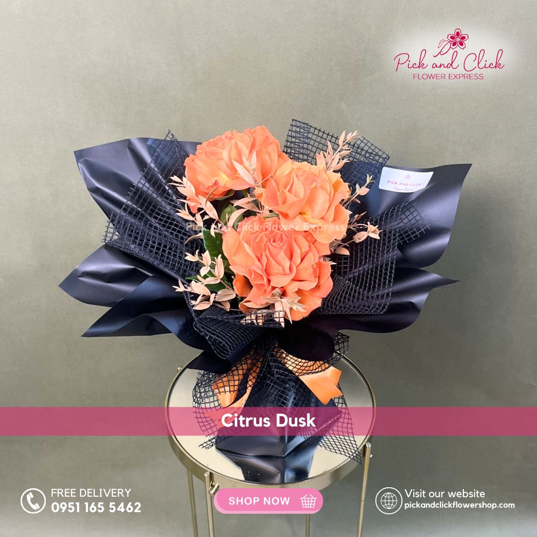 Citrus Dusk bouquet featuring three orange roses accented with orange sprayed parvi leaves in a modern mini hand bouquet.