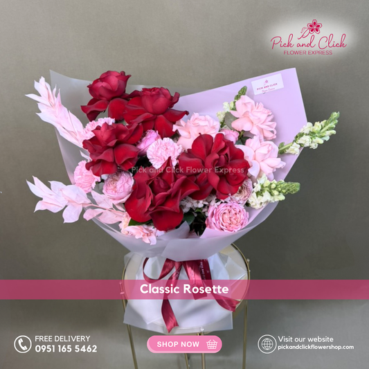 Classic Rosette Bouquet featuring imported red and light pink roses, pink carnations, pink spray roses, snapdragons, and dried melaleuca arranged in an elegant romantic hand bouquet.