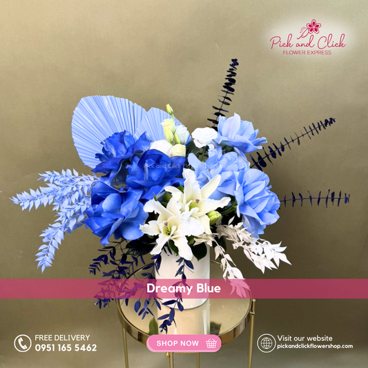 Dreamy Blue vase arrangement featuring light and dark blue sprayed white roses, white stargazers, white lisianthus, dried ruscus, blue sprayed foliage, and anahaw in a premium vase, perfect for elegant gifting and refined interiors.