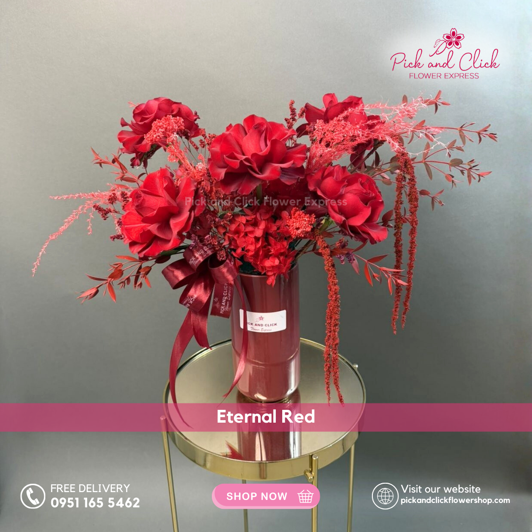 Eternal Red vase arrangement featuring imported red roses and red sprayed dried fillers in a luxurious monochromatic red floral design.