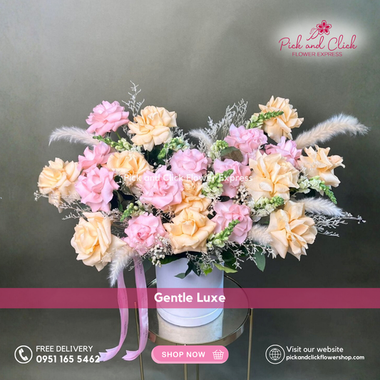 Gentle Luxe vase arrangement featuring imported light pink and peach roses, snapdragons, dried misty white, pampas, and rosal styled in an elegant glass vase.