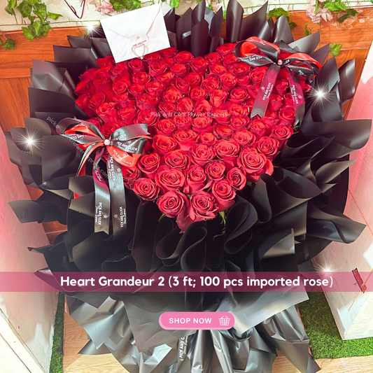 Heart-shaped arrangement of 100 long stem imported red roses in black wrap — romantic luxury bouquet