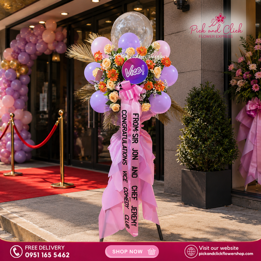 Joyful Luck Flower Stand featuring imported roses, gerbera, dried palm leaves, gypsophila, balloons, and a customized printed ribbon, a vibrant and festive floral arrangement perfect for grand openings, celebrations, and special events in the Philippines.