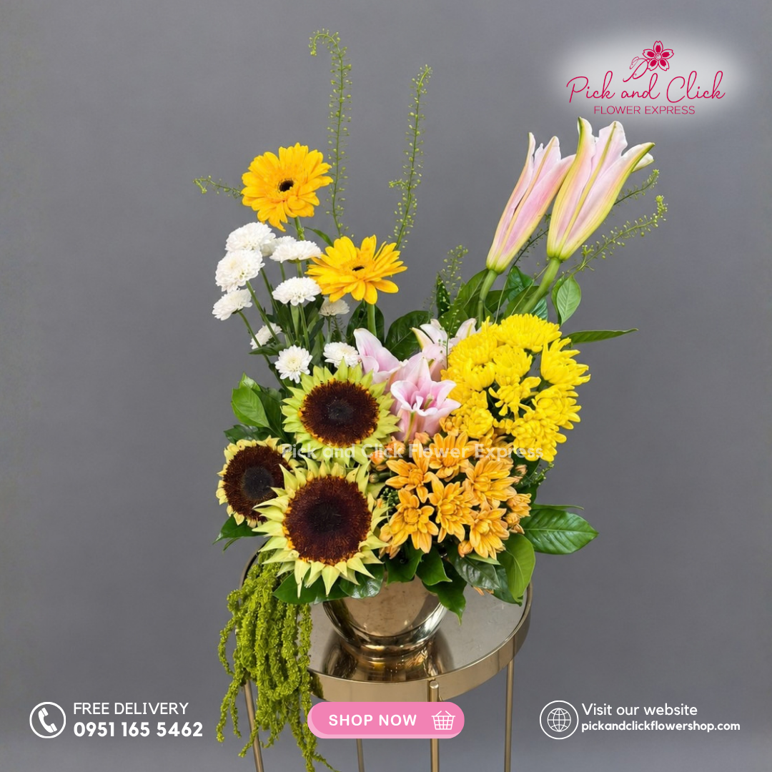 Mellow Gold Vase Arrangement featuring Sunflowers, Gerberas, Lily/Stargazer, Mixed Spray Mums, and Assorted Green Fillers in a vibrant yellow and orange floral arrangement in the Philippines.