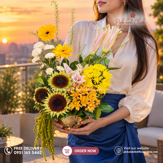 Mellow Gold Vase Arrangement featuring Sunflowers, Gerberas, Lily/Stargazer, Mixed Spray Mums, and Assorted Green Fillers in a vibrant yellow and orange floral arrangement in the Philippines.