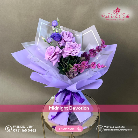 Midnight Devotion bouquet featuring moody blues roses, violet lisianthus, and purple sprayed Bells of Ireland shell in a dramatic premium hand bouquet.