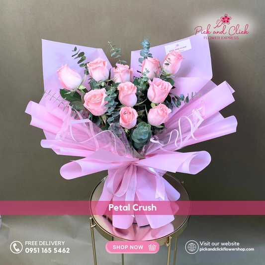 Bouquet of pink roses with a pink ribbon on a reflective surface, branded 'Pick and Click Flower Express'.