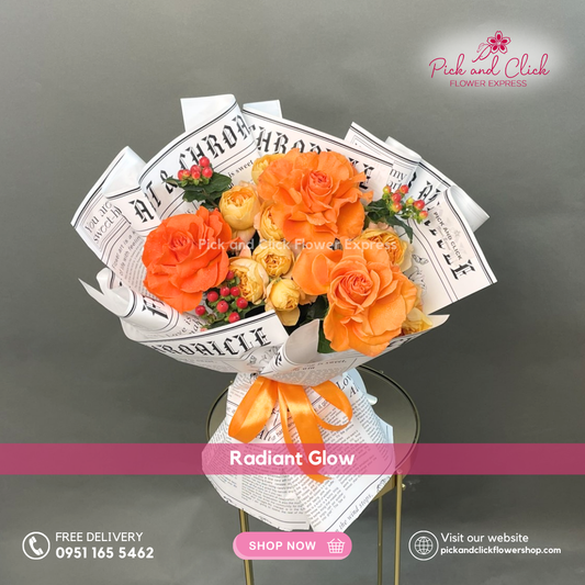 Radiant Glow bouquet featuring orange roses, yellow spray roses, and berries arranged in a vibrant cheerful hand bouquet.