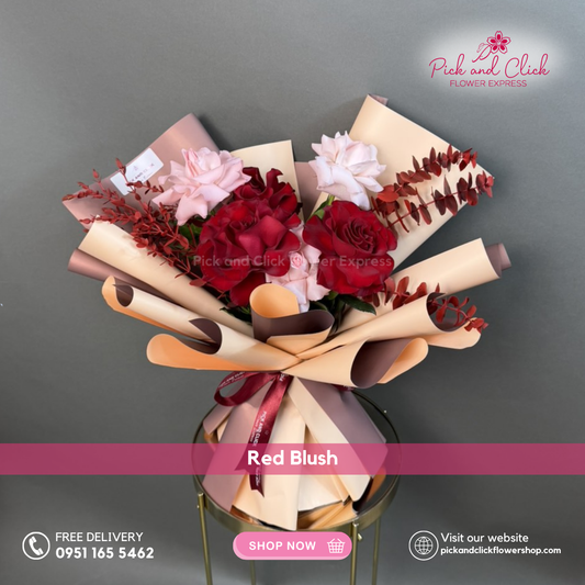 Red Blush bouquet featuring imported red and light pink roses with red sprayed parvi leaves and eucalyptus in a petite romantic arrangement.
