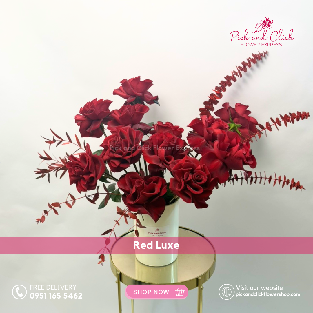 Red Luxe vase arrangement featuring imported red roses accented with red sprayed parvi leaves and eucalyptus styled in a modern elegant vase.