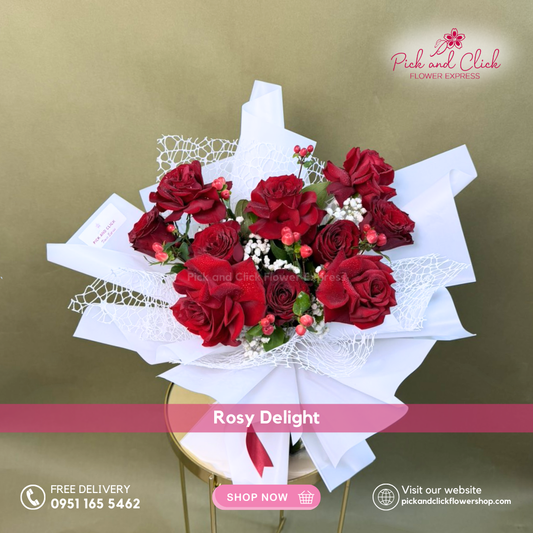 Rosy Delight Bouquet featuring 10 imported red roses accented with berries and soft gypsophila in an elegant romantic hand bouquet.