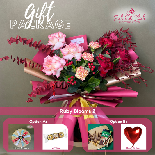 Ruby Blooms 2 bouquet featuring two tone pink and imported red roses, two tone orange yellow carnations, berries, and red sprayed foliage arranged in a premium gift package with optional add ons.