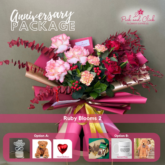 Ruby Blooms 2 bouquet featuring imported red and two tone pink roses, carnations, red sprayed eucalyptus, parvi leaves, and berries arranged in an anniversary gift package with optional add ons.