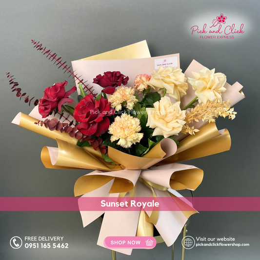 Sunset Royale bouquet featuring peach roses, imported red roses, two tone carnations, gold sprayed parvi leaves, and red sprayed eucalyptus arranged in a luxe dramatic hand bouquet.